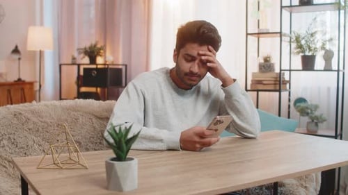Man Looking at Smartphone in Bright Home Setting