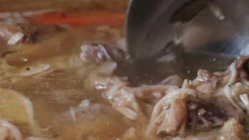 Meat Cooking in a Pot Being Stirred