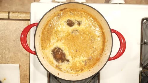 Organic wild rice mushroom soup simmering in a pot on the stove - overhead view WILD RICE SERIES