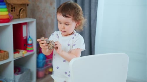 Little girl plays with kinetic sand in her room