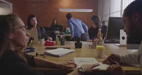 Groupe de jeunes employés travaillant au bureau la nuit. Personnel au travail le soir en co-working