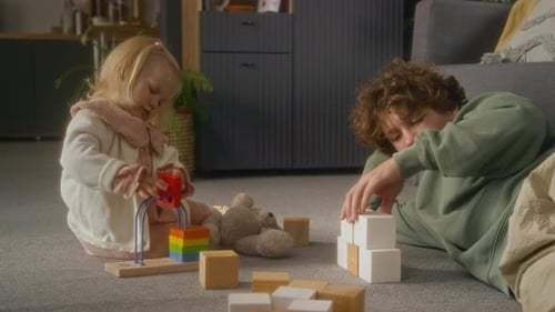Teen Brother and Sister Playing with Wooden Toys