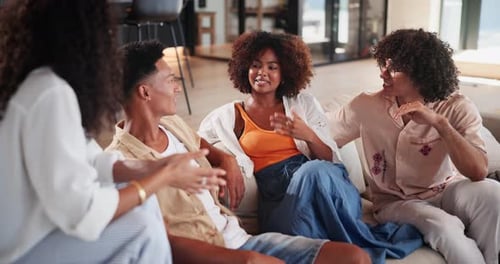 Friends Laughing and Talking on Sofa Together