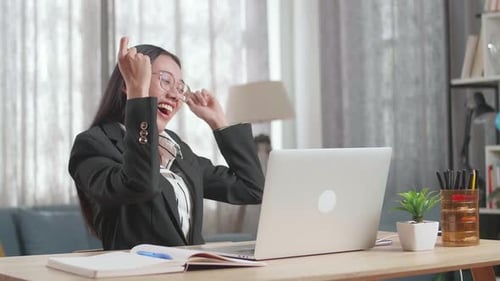 Excited Woman Celebrates Success With Laptop