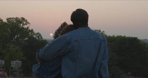 Couple Embracing at Sunset in a Rural Setting