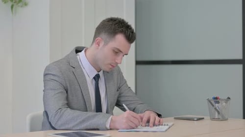 Young Businessman Working on Documents in Office