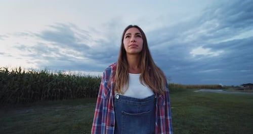 Portrait of a Woman Smiling and Looking Around in a Green Field of Corn.