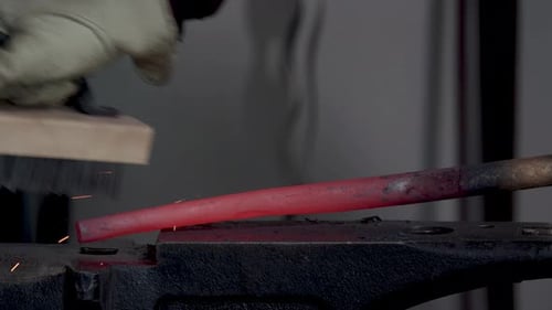 Blacksmith Brushing Red Hot Metal