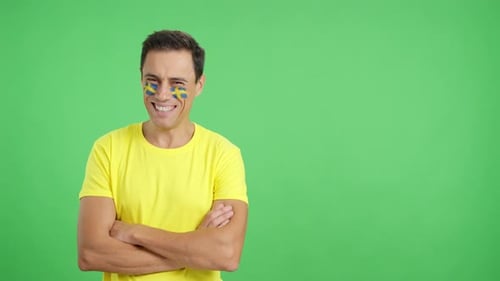 Man Standing with Swedish Flag Painted on Face Smiling