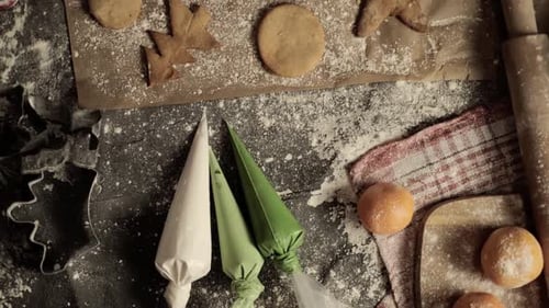 Close-up of a woman's hand making gingerbread cookies in the form of a Christmas tree and a gingerbr