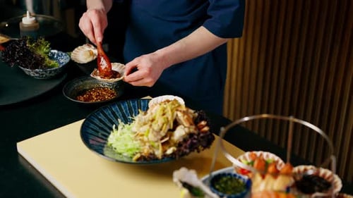 Closeup in a Japanese Restaurant Chef in Blue Prepares an Expensive Plate of Seafood