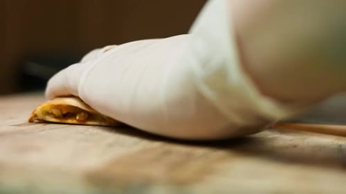 Cutting Golden Quesadilla with Savory Filling on Board