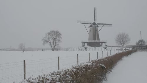 Dolly einer traditionellen Windmühle im verschneiten Feld bei Winterwetter