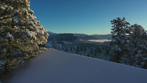 Flying over a cabin to reveal a winter wonderland in Colorado