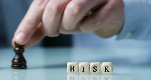Slow motion macro of the word "Risk" made of the wooden letter blocks . Concept of financial marke