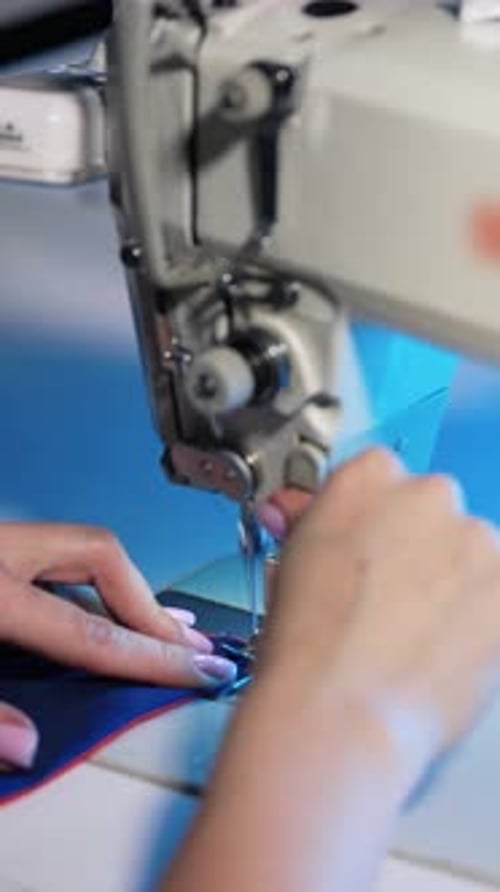 Woman works at sewing machine.