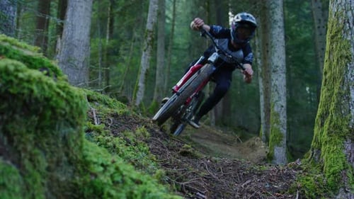 A mountain biker kicks up some moss in slow motion