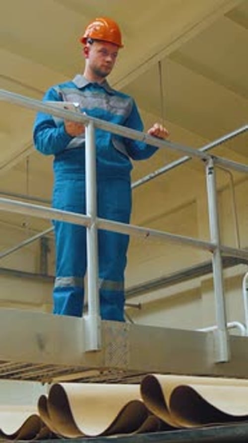 An Engineer Worker at Packaging Factory Controls a Corrugated Cardboard Conveyor Focused Technician