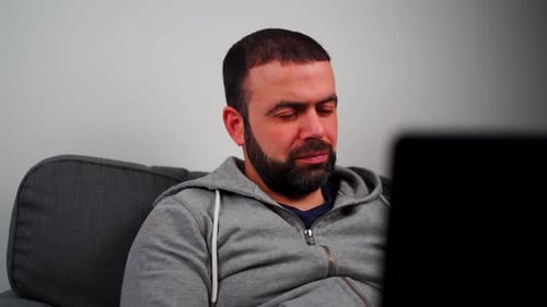 Man Working On Laptop In The Living Room - Close Up