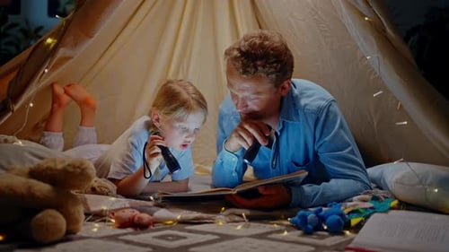 Father and Child Read Book Inside Blanket Fort