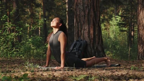Woman Practicing Yoga in a Tranquil Forest