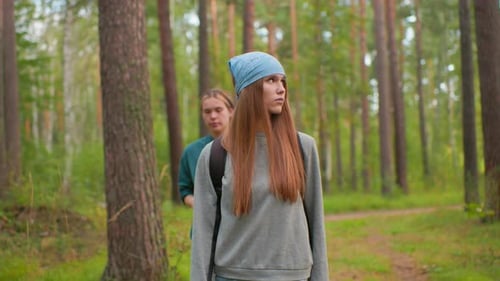 Hikers Walking Along Serene Forest Trail with Thoughtful Gaze