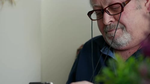 Senior Man Using a Phone Indoors