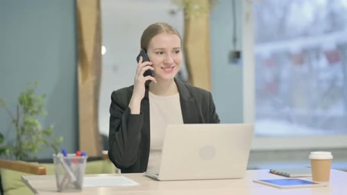 Woman Answers Mobile Phone at Workplace