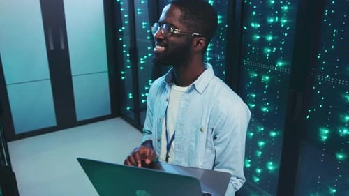 Man with Laptop in Modern Server Room