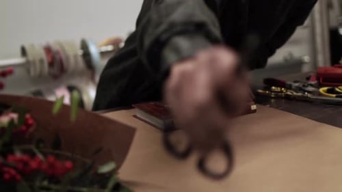 Woman Prepares to Wrap Colorful Bouquet With Brown Paper