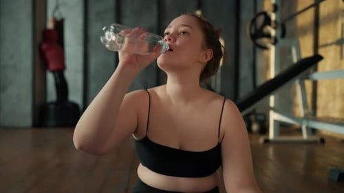 Woman Hydrating During Workout at Gym