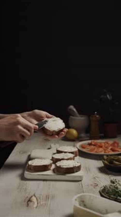 Hands Close Up, Spread Slices Of Pickled Cucumber On Slices Of Bread With Cream Cheese
