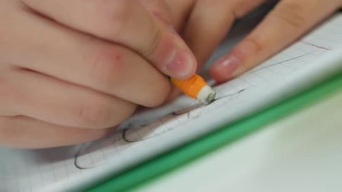 Corrección cuidadosa de las marcas del lápiz, centrado en limpiar las líneas del lápiz con precisión, primeros planos de las manos