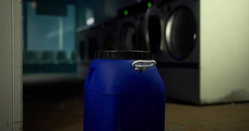 La zone des machines à laver comprend un conteneur bleu à proximité des machines à laver