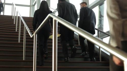 Business People Walking Up Stairs in Corporate Building