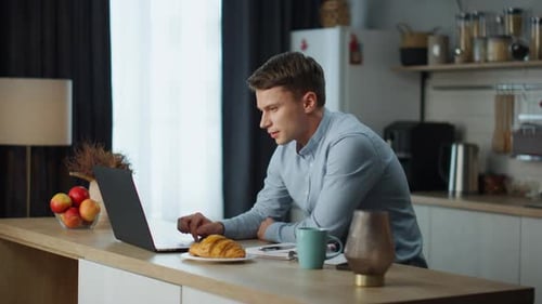 Konzentrierter Mann spricht auf einem Zoom-Meeting und diskutiert Geschäftsprozesse mit Kollegen, die zu Hause sitzen...