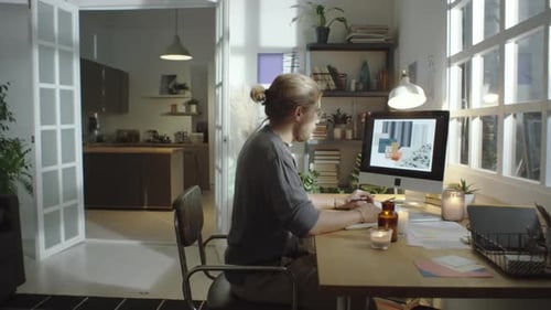 Young Adult Working at Desk in Bright Room