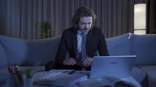 Young Adult Working on Laptop at Home at Night