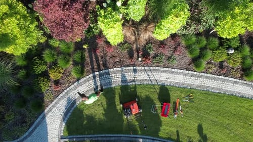 Garden Worker Cleaning Garden Brick Paths Using Air Blower