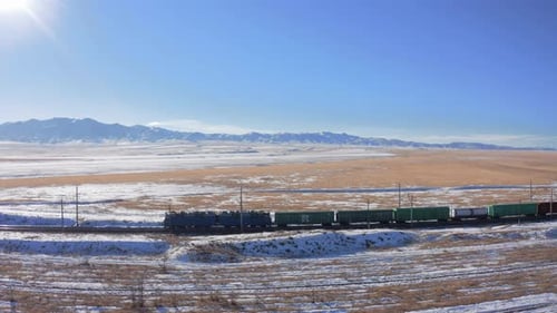 Flight on a drone along the railway and a moving train with freight cars