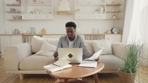 Man Working on Laptop at Home on Couch