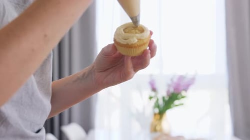 Decorating Cupcake With Icing in Bright Kitchen