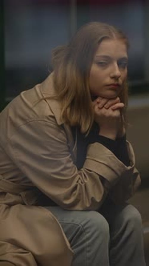 A Contemplative Woman Dressed in a Stylish Beige Coat Exuding a Serene and Peaceful Vibe
