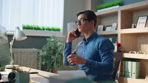 Talking Man Drinking Coffee in Modern Office. Closeup Serious Businessman Speaking Mobile