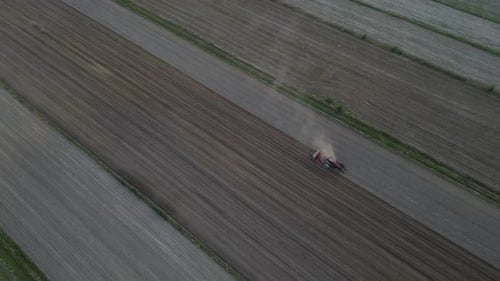 Aerial View of Tractor Plowing Field on Sunny Day
