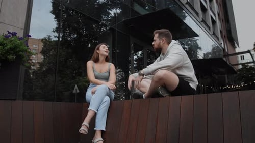 Young Adults Sitting Talking Outside Modern Building