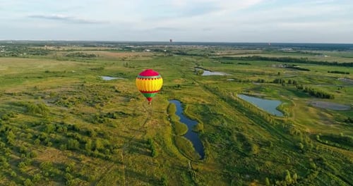 Hot Air Balloon Flies Over Green Fields