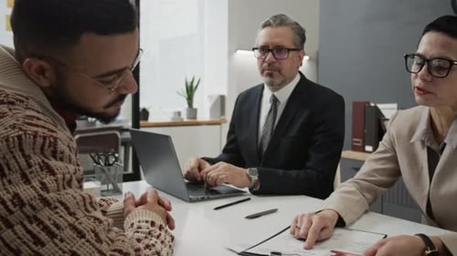 Hiring Manager Discussing Resume with Gen Z Applicant, Colleague Taking Notes