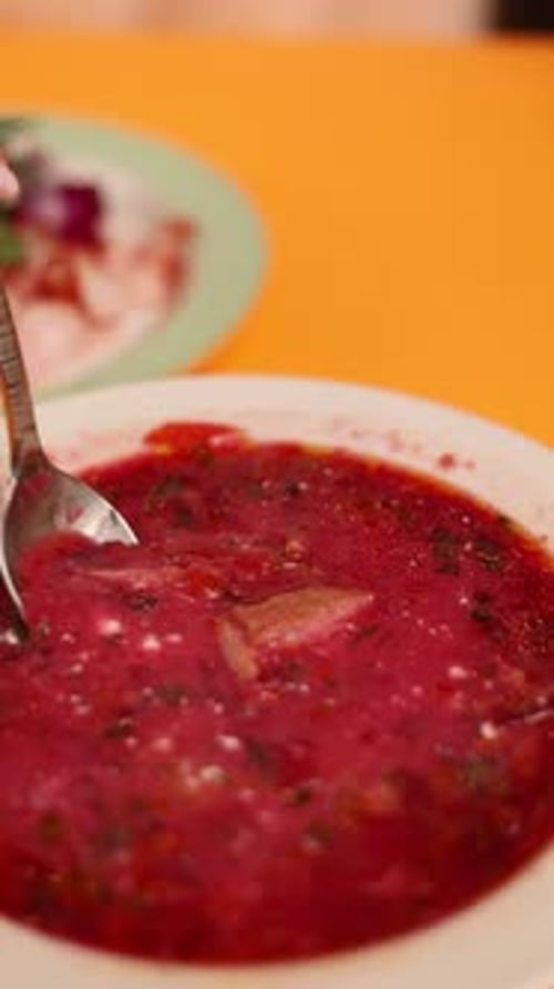 Un plato de borsch ucraniano sobre un fondo naranja
