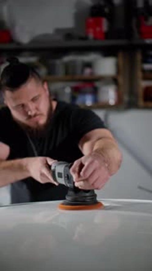 Man Polishing a Car With Power Tool